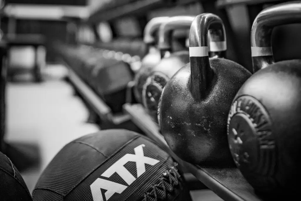 Kettlebells stehen in einer Reihe, im Vordergrund liegt ein Medizinball