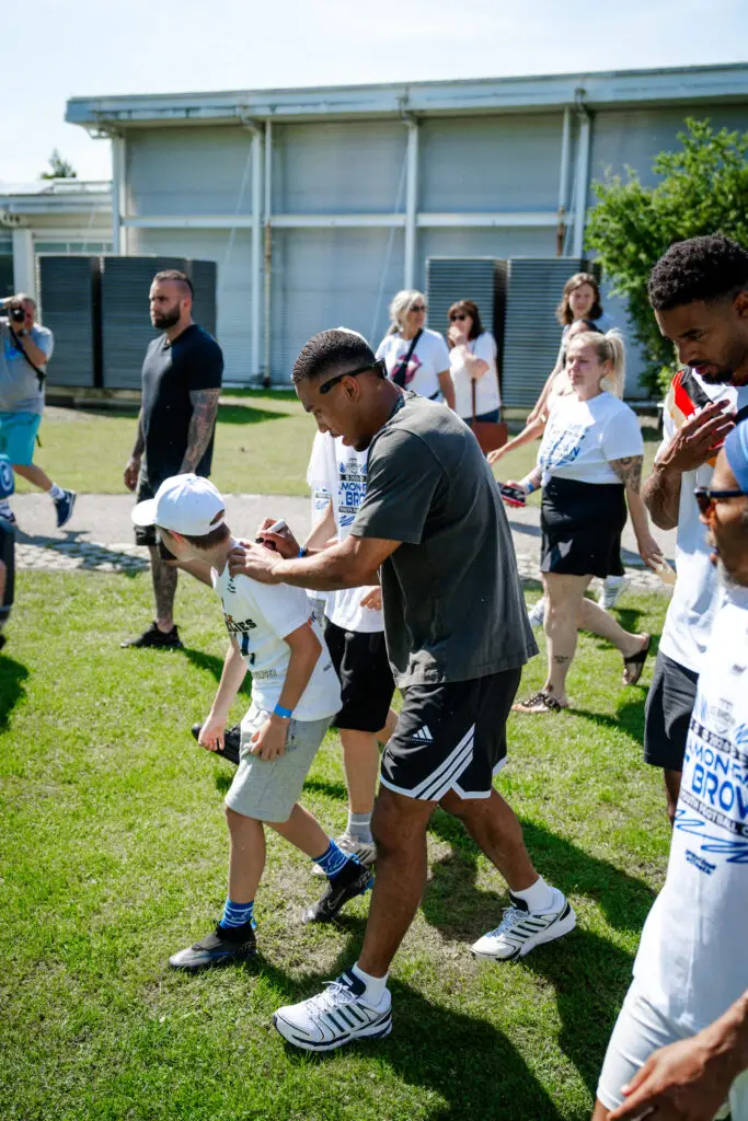 Junge erhält Autogramm von NFL Star St Brown beim Football Camp in Oberhaching