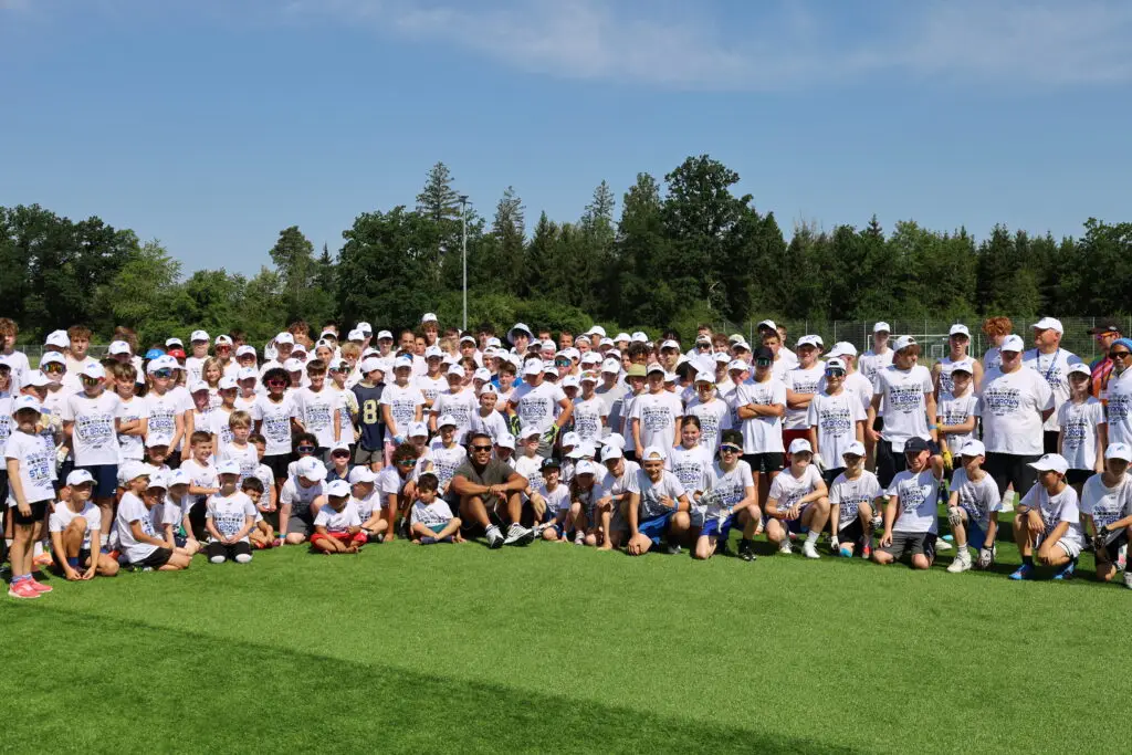 Kinder und Jugendliche beim American-Football-Camp mit zahlreichen Teilnehmenden auf einem Kunstrasenplatz in Oberhaching