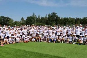 Kinder und Jugendliche beim American-Football-Camp mit zahlreichen Teilnehmenden auf einem Kunstrasenplatz in Oberhaching