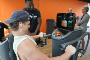 Ein Athlet der Munich Ravens absolviert eine Trainingseinheit an einem EGYM-Kraftger&auml;t im S.P.O. Club der Sportschule Oberhaching. Ein Trainer begleitet das individuelle Krafttraining, w&auml;hrend das intelligente EGYM-System die &Uuml;bung digital unterst&uuml;tzt. Der moderne Trainingsbereich richtet sich an Leistungs-, Vereins- und Freizeitsportler.