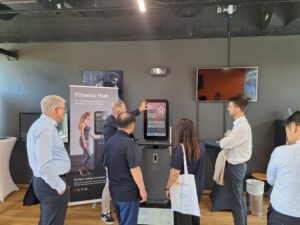 Gruppe von Besucherinnen und Besuchern bei einer Präsentation im Fitness Hub der Sportschule Oberhaching