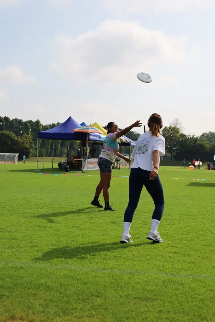 Bildergalerie vom Frisbee Festival M&uuml;nchen an der Sportschule Oberhaching mit Spielszenen auf dem Sportplatz und in der Halle, Turnierst&auml;nden, Zuschauerinnen und Zuschauern sowie verschiedenen Frisbee-Disziplinen wie Disc Golf, Ultimate Frisbee und Freestyle.