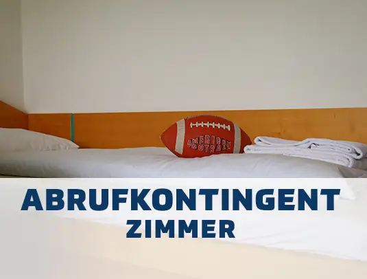 Bett mit einem Football drauf mit Hinweis auf Abrufkontingent f&uuml;r Zimmer.